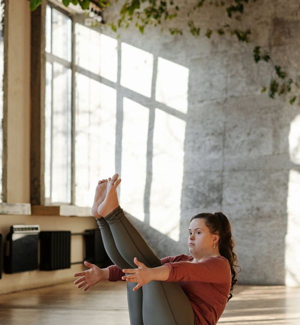 Person doing a gentle morning exercise on a mat by a large window.